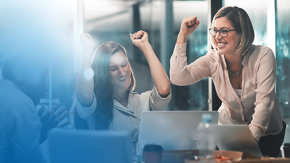 Excited workers cheering after a successful meeting